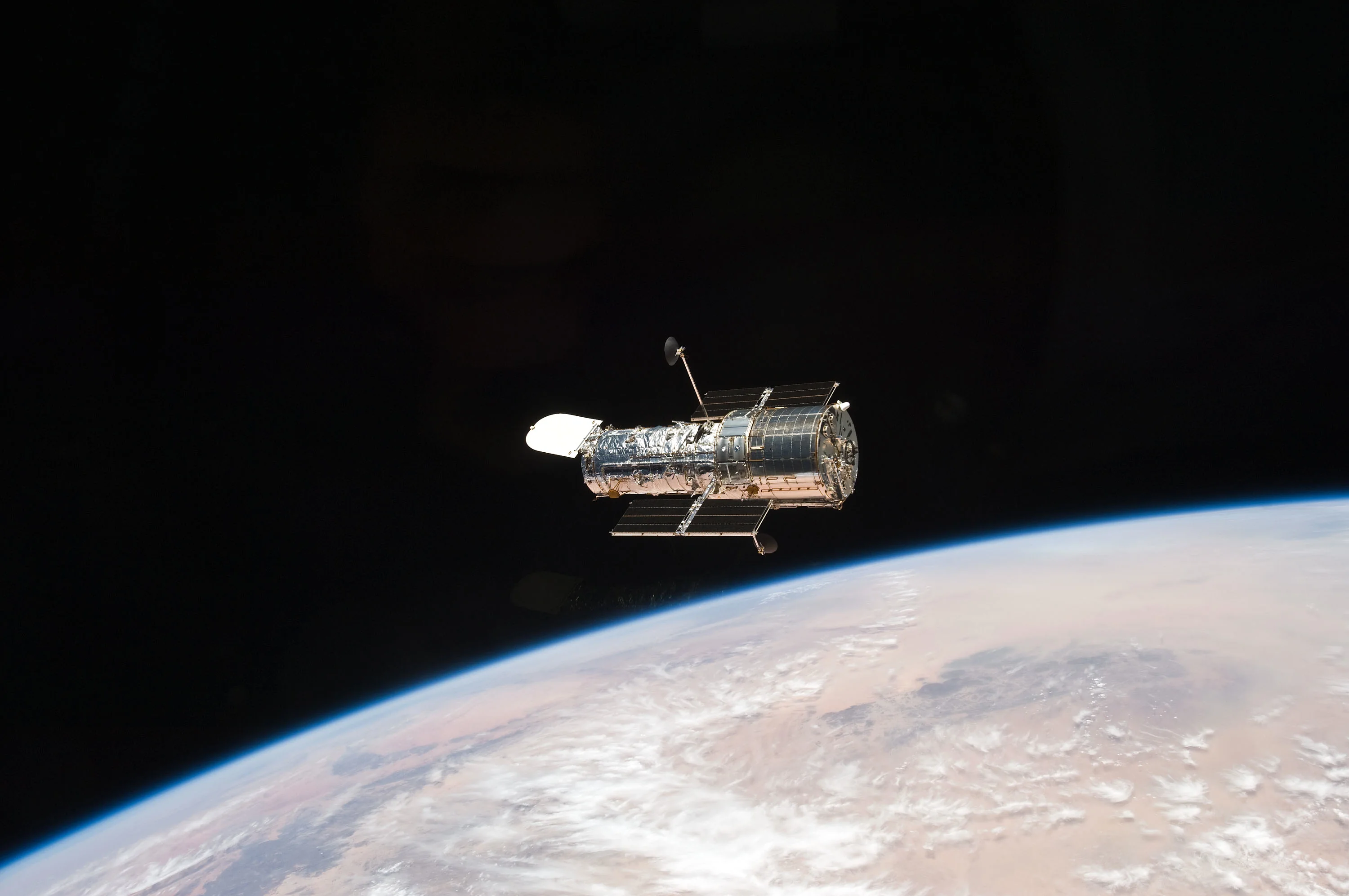 NASA photograph of the Hubble Space Telescope after Servicing Mission 4, photographed from Space Shuttle Atlantis in 2009 above Earth.